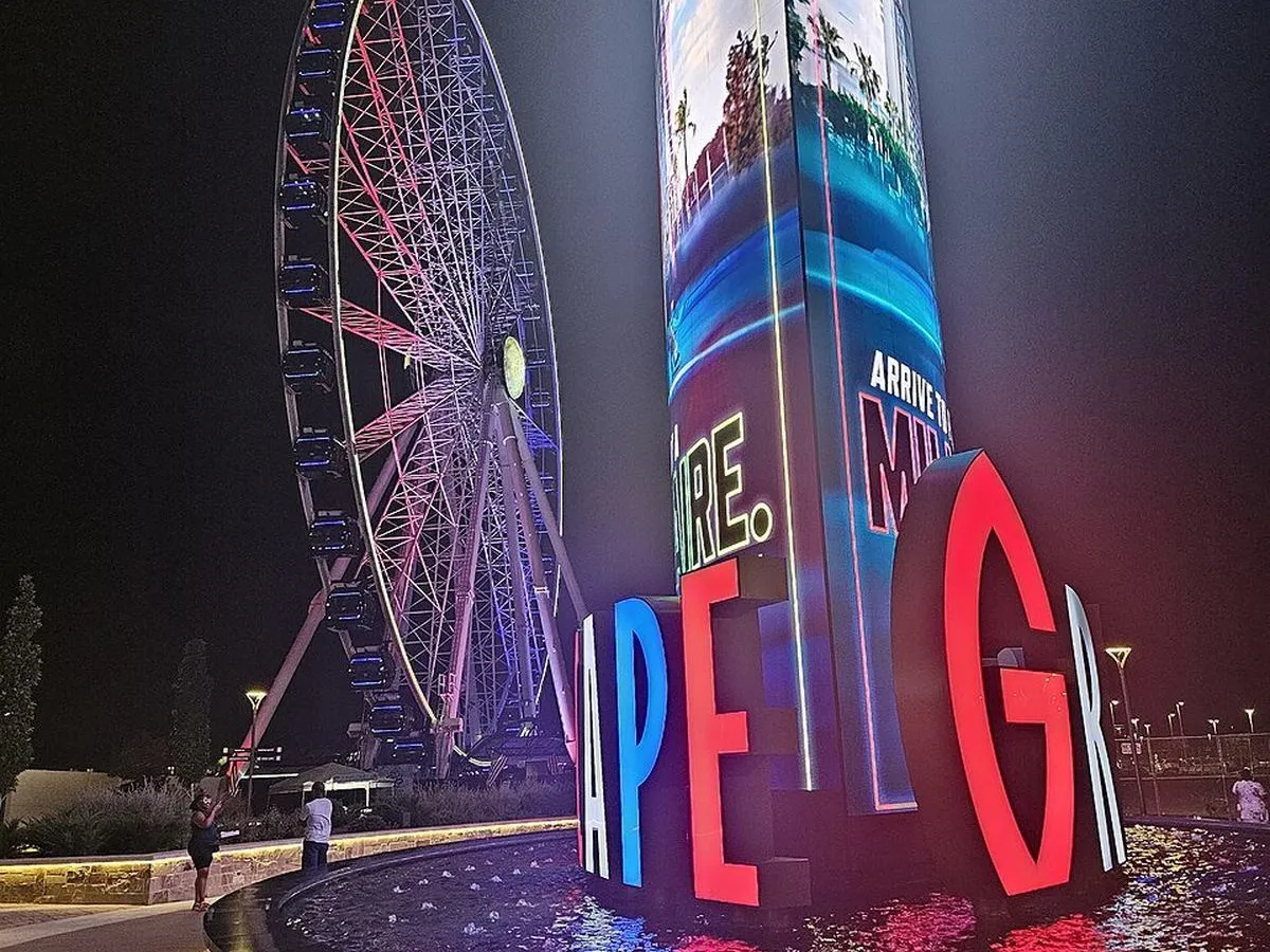 Nighttime view of the Grandscape entertainment district's Ferris wheel and light-up sign in The Colony, Texas